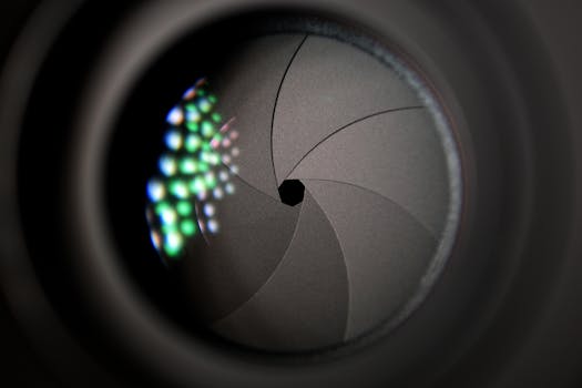 pexels-photo-414781-414781 Detailed image of a camera lens aperture showing mechanical blades.